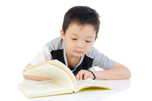 Asian boy reading a book on the floor