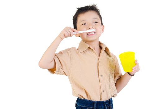 Closeup cute asian boy with a toothbrush in hand smiling and go to brush teeth oral health concept. Isolated on white background. 