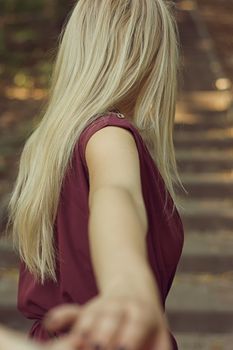 Rear view of young woman going up the stairs in the park