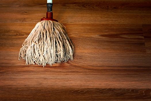 close up of cleaning brown wooden parquet with a mop
