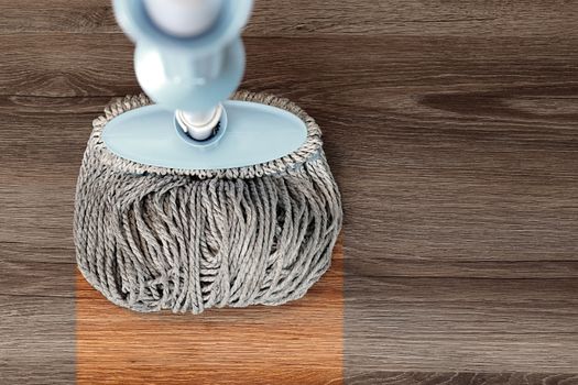 washing dirty wood floor with big mop