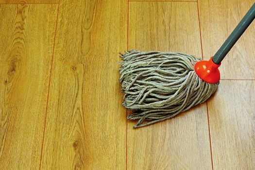 washing the wooden floor with wet mop