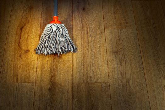 cleaning parquet wooden floor with wet mop