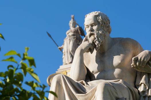 classical statue of Socrates from side with athena statue above and back