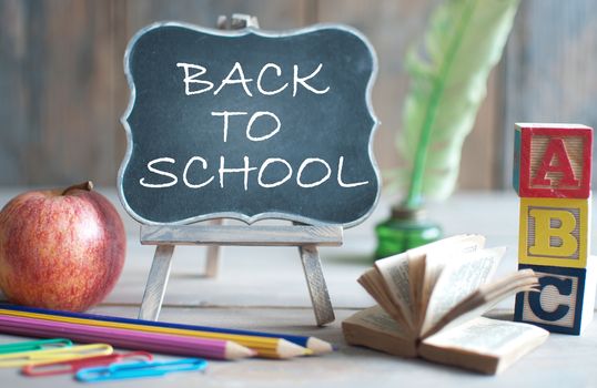 Back to school blackboard with school stationery, and apple