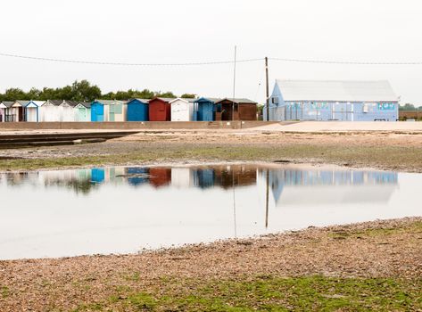 beautiful scene of beach huts with reflections in water in front; England; UK