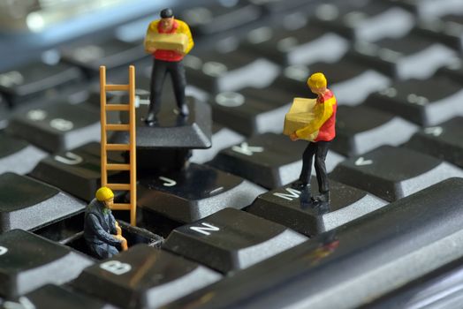 Workers figurnes repairing keyboard