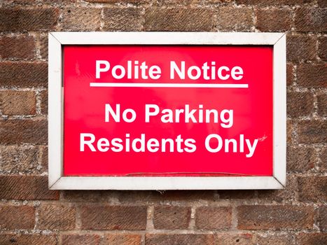 close up of red placard sign outside houses no parking residents only; England; UK