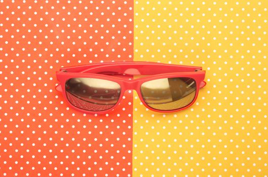 Orange sunglasses with colorful topped background