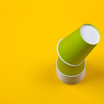 Set of green paper cups on a yellow background