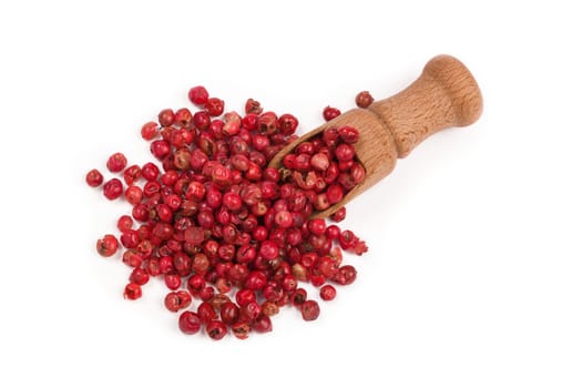 red peppercorns isolated on white background, pink peppercorns in a wooden scoop