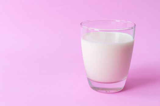 Closeup glass of milk on pink background, food and drink for healthy concept, selective and soft focus