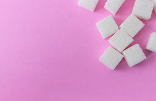 Closeup top view sugar cubes on pink background, food and health care concept, selective focus