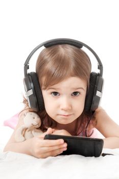 the little girl listens to music in earphones