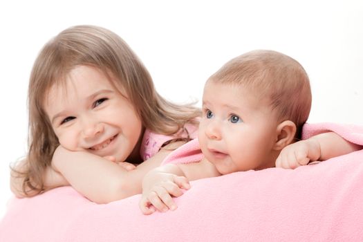 two little girls of the sisters lie on a pink plaid