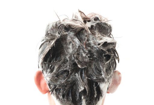 Closeup young man washing hair with white background, health care concept