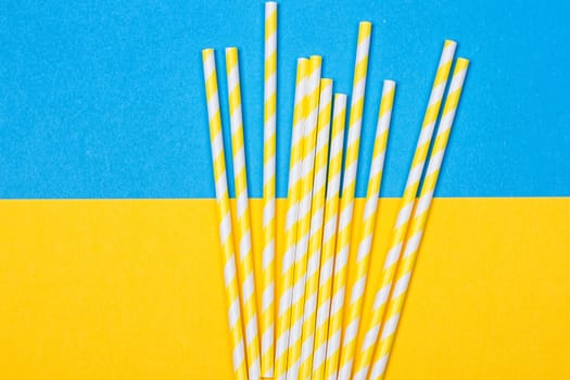 close-up colorful fancy drinking straws, fancy tube for party on the yellow and blue background