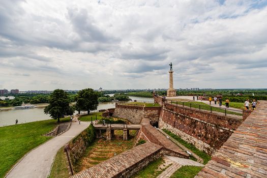 Belgrade fortress and Kalemegdan park with dramatic clouds and green foliage