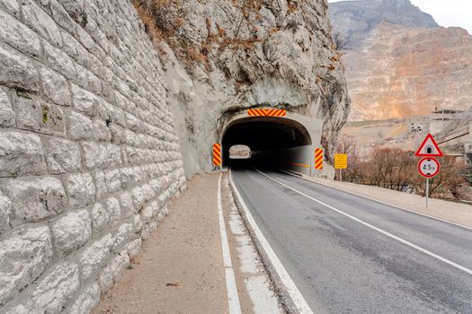 Tunnel on the road in the canyon during the winter on a cloudy day