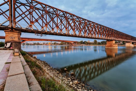 Steel bridge across river at night with artificial lightning