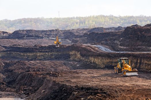 open coal mining pit with heavy machinery