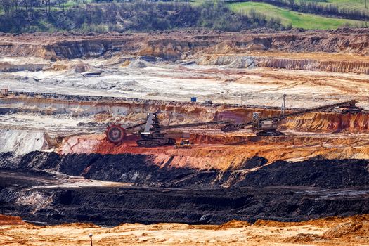 open coal mining pit with heavy machinery