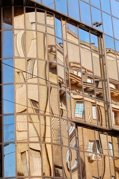 reflection of stone facade on modern glass facade