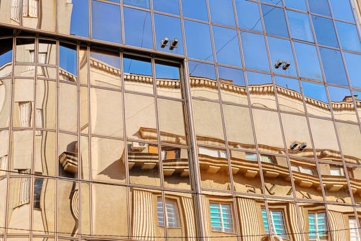 reflection of stone facade on modern glass facade