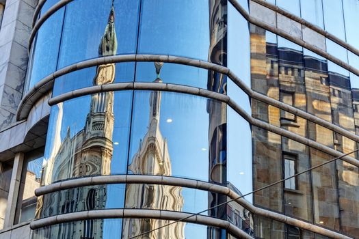 reflection of stone facade on modern glass facade