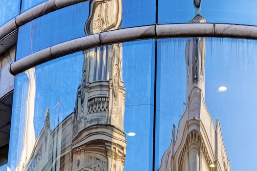 reflection of stone facade on modern glass facade