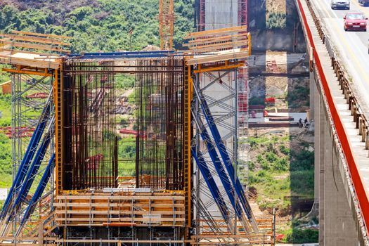 high altitude concrete bridge construction with crane and framework