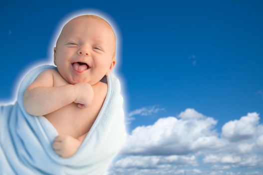 Beautiful Laughing Baby Boy Wrapped in His Blanket With A Blue Sky Background.