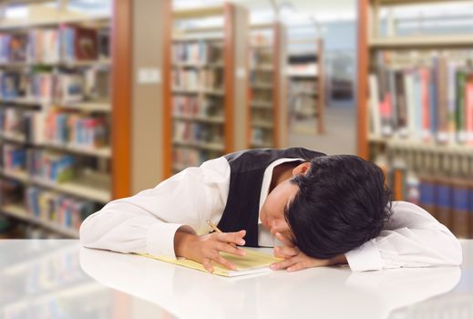 Young Female Mixed Race Student Stressed and Frustrated In Library with Blank Pad of Paper.