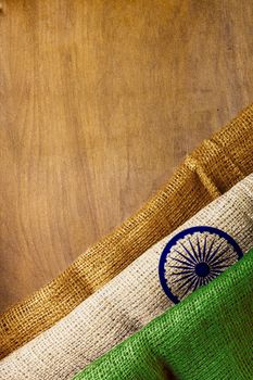 National flag of India from a rough canvas fabric on a wooden background.