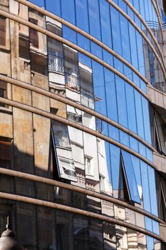 reflection of stone facade on modern glass facade