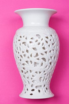 White ceramic vase on a pink background