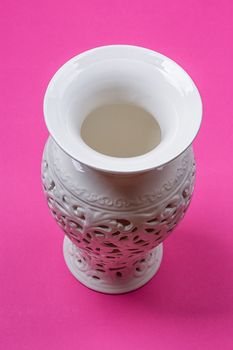 White ceramic vase on a pink background