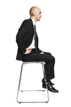 Profile view of young calm office worker sitting on a chair. Studio shot isolated on white background.