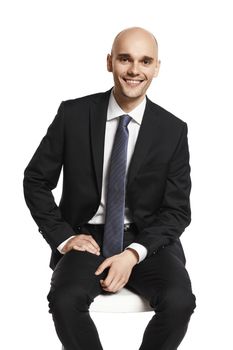 Young elegant man sitting on a chair. Studio shot isolated on white.