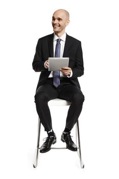 Young businessman with digital tablet looking right.