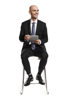 Young businessman with digital tablet looking left.