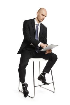 Concentrated man working on tablet. Side view of young man isolated on white background.