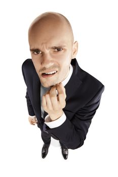 Young businessman scratches his chin and looks at the lens. Above view.