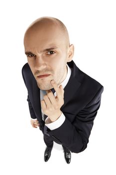 Young businessman scratches his chin and looks at the lens. Above view.