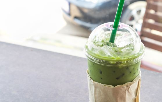 Closeup Ice of matcha latte in plastic glass take away cup, selective focus