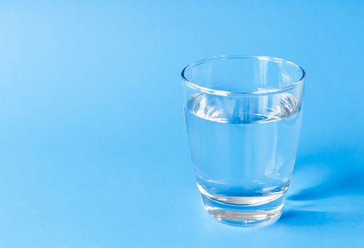 Water in glass on blue background