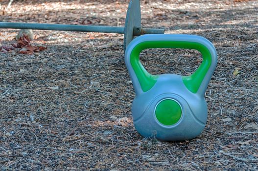 Homemade gym in a garden with barbell and ketttlebell