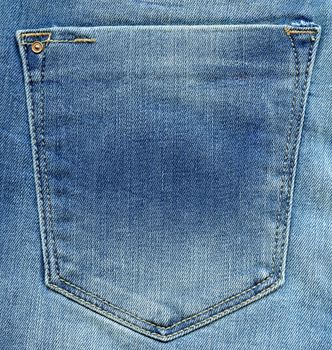 Jeans pocket. Shabby blue denim. Light blue fabric texture