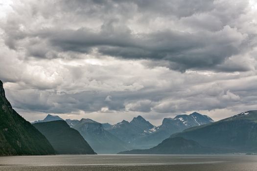 Mountains along the Romsdalsfjorden near Andalsnes under a cloudy sky, Norway