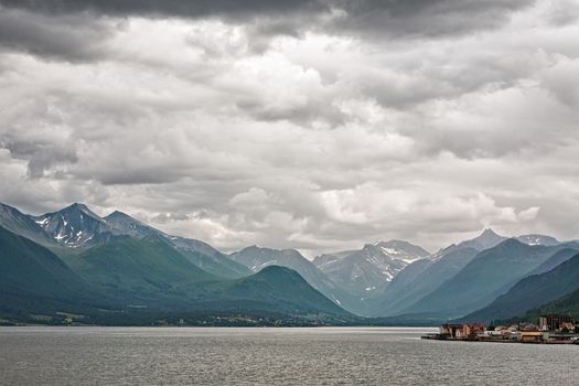 Andalsnes and mountains along the Romsdalsfjorden under a cloudy sky, Norway